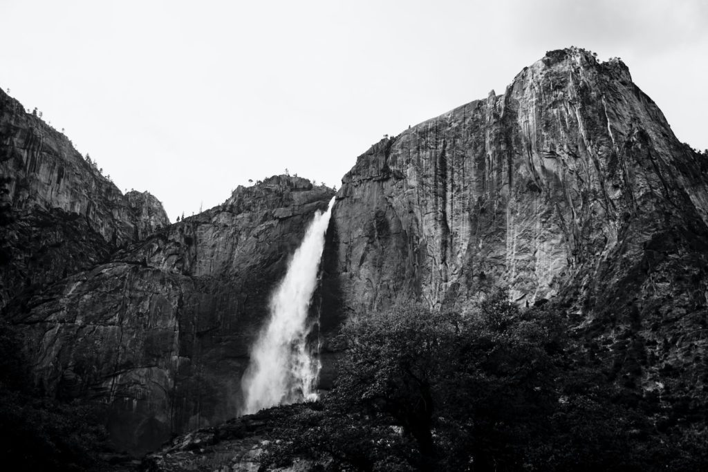 grayscale photography of plunge waterfall at daytime