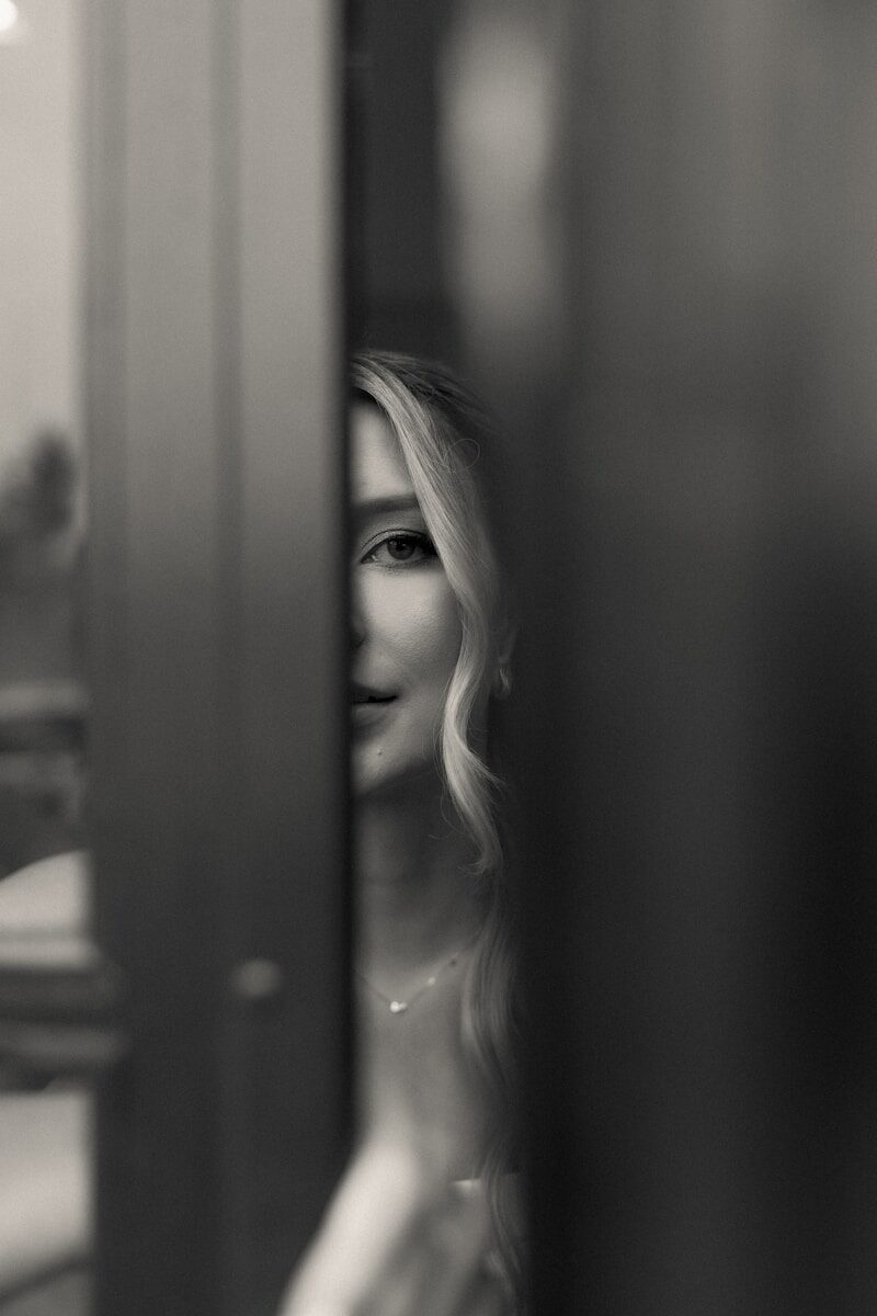 Black and white portrait of a woman peeking.