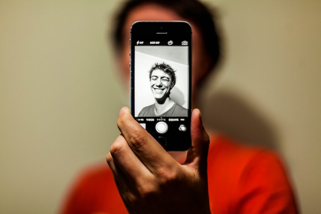 אדם מחזיק חלל אפור אייפון 5s מצלם תמונה